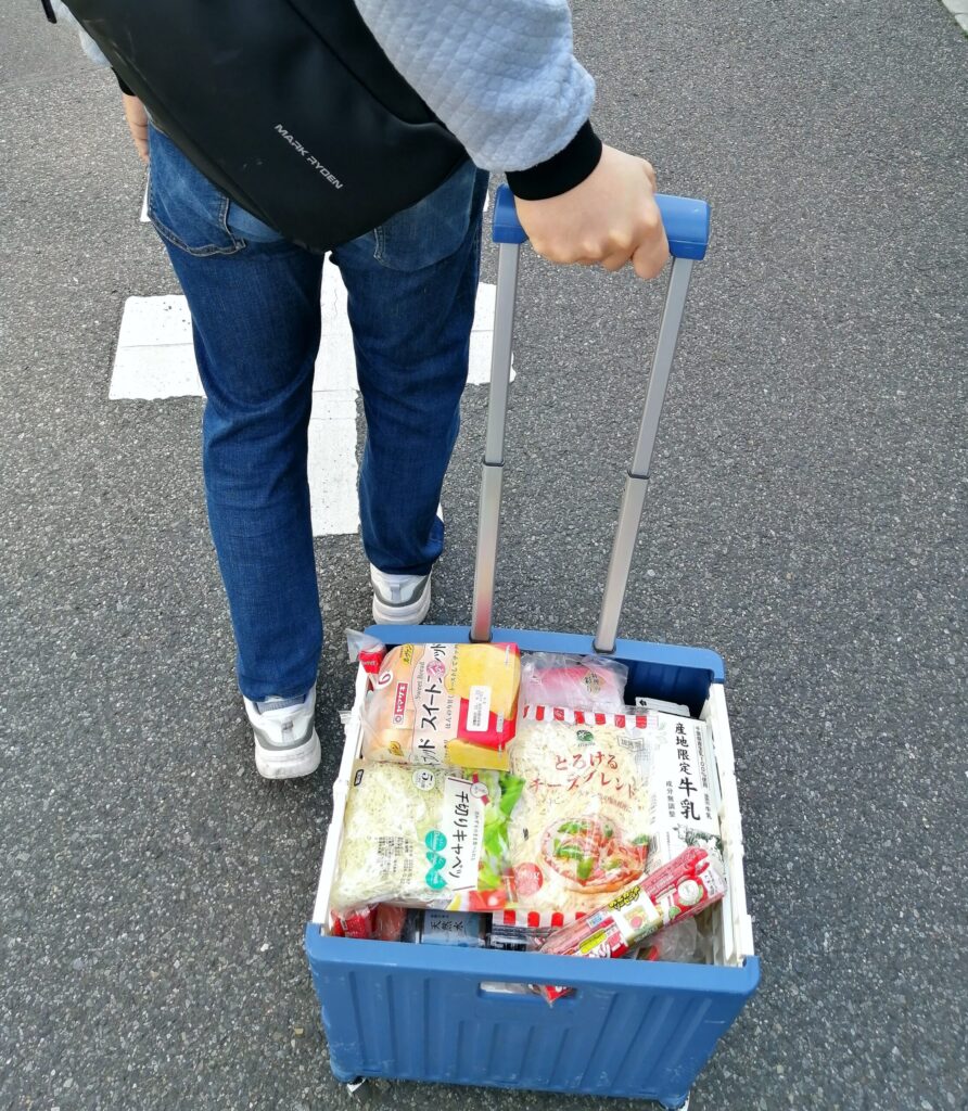 まとめ買いで買った荷物をキャリー型のボックスで運んでくれる旦那の画像