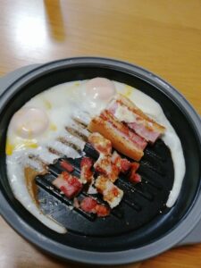 レンジグリルで半分は目玉焼き、半分はベーコンを焼いた画像